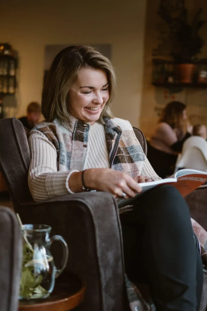 Monique Struijk leest een boek over hybride samenwerken in een zithoek